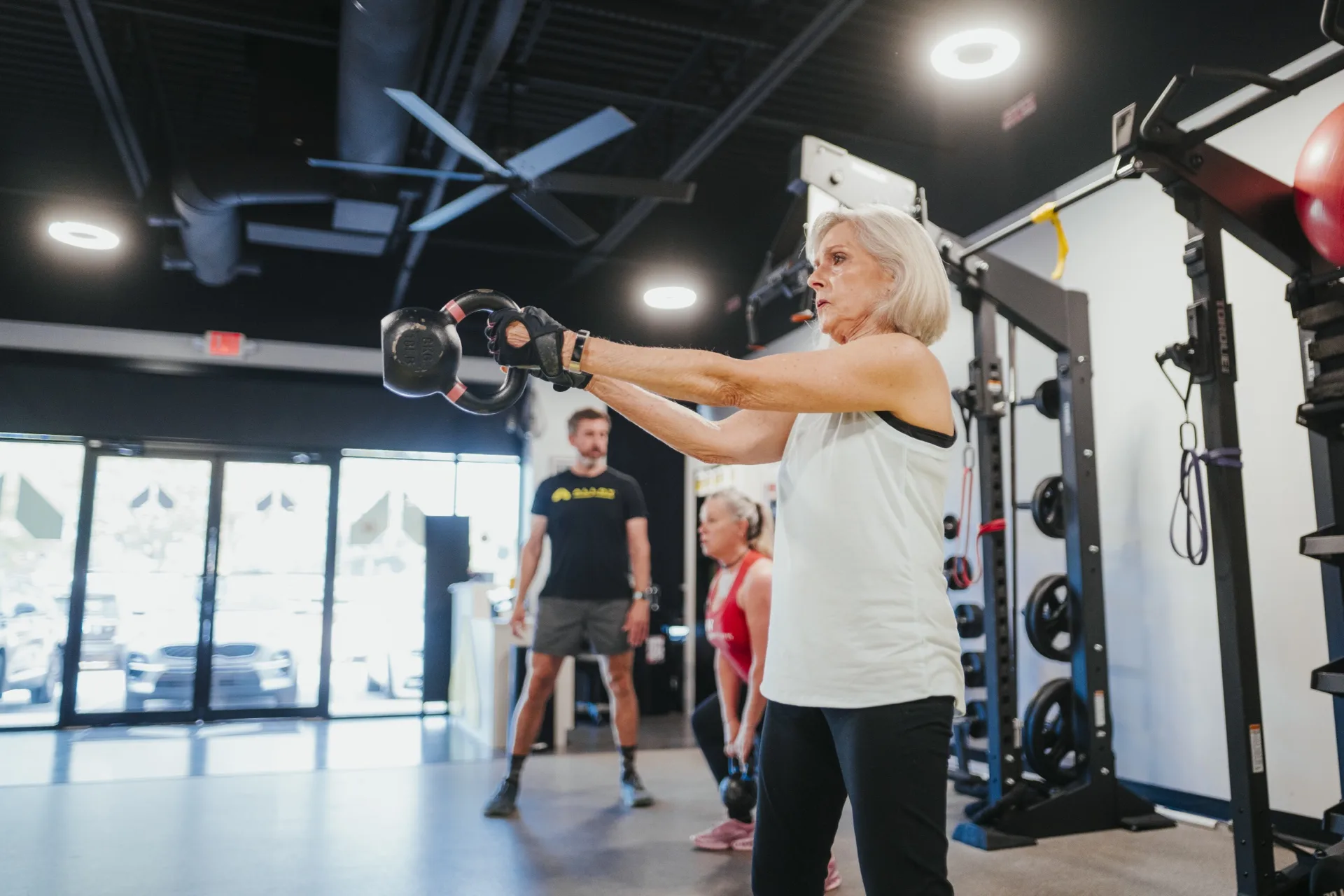 Coach-led kettlebell training in a small group personal training session at Alloy Personal Training in Pinecrest, FL